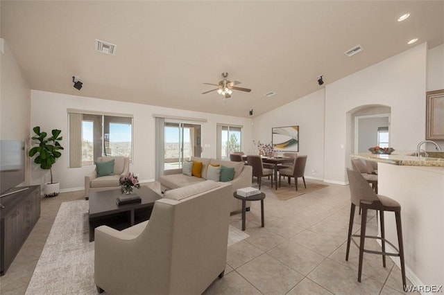 living room with light tile patterned floors, visible vents, arched walkways, a ceiling fan, and lofted ceiling