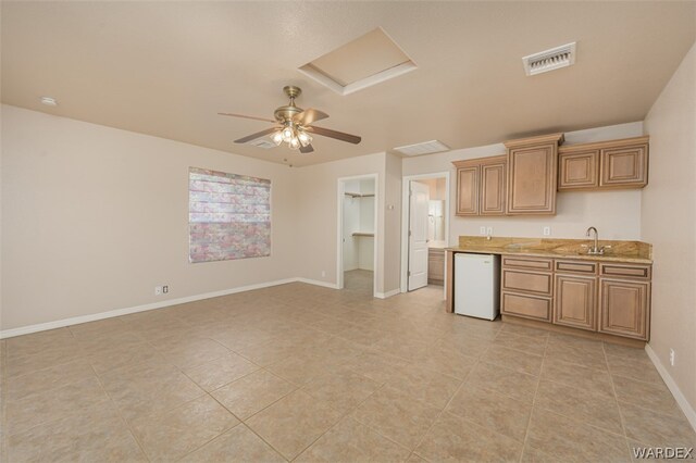 kitchen with baseboards, visible vents, dishwasher, ceiling fan, and a sink