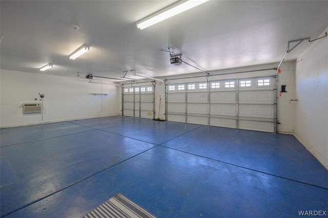 garage featuring a garage door opener, baseboards, and a wall mounted AC