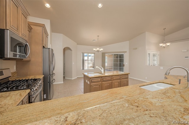 kitchen featuring a chandelier, stainless steel appliances, a sink, vaulted ceiling, and pendant lighting