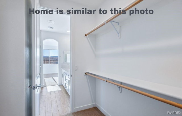 walk in closet with light wood-type flooring