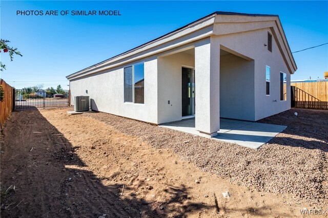 back of house with a patio, central air condition unit, a fenced backyard, and stucco siding