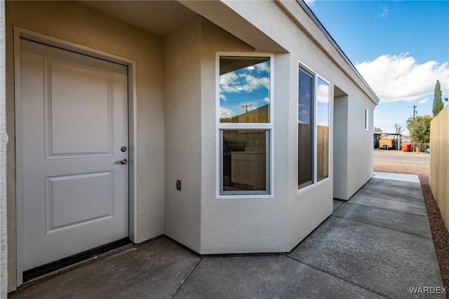entrance to property featuring stucco siding