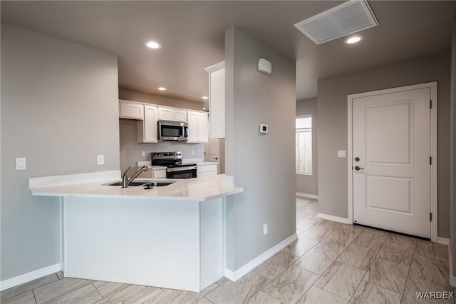 kitchen with a sink, white cabinetry, recessed lighting, stainless steel appliances, and light countertops