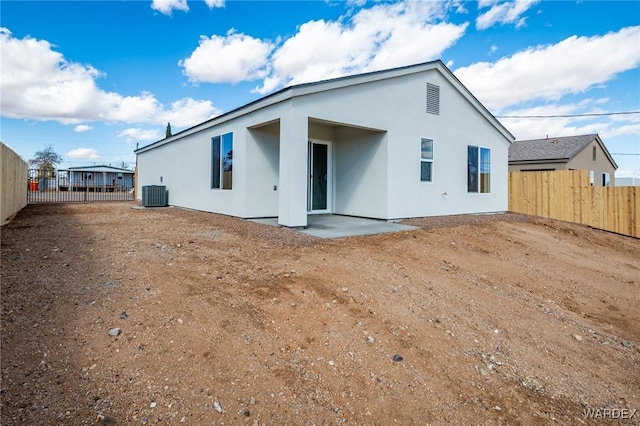 back of property with cooling unit, a patio area, stucco siding, and fence