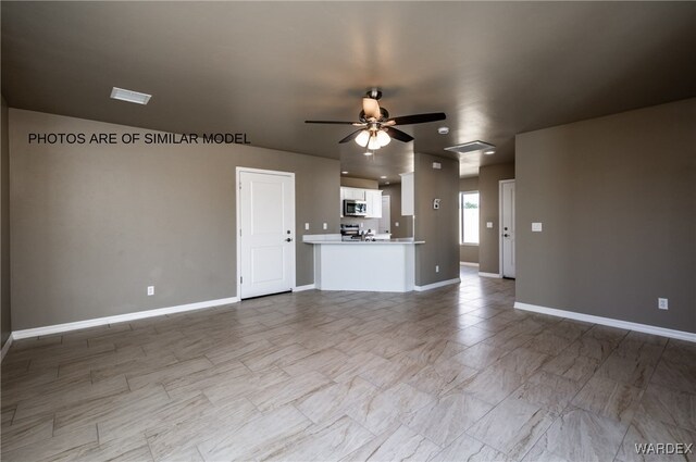 unfurnished living room with baseboards and a ceiling fan