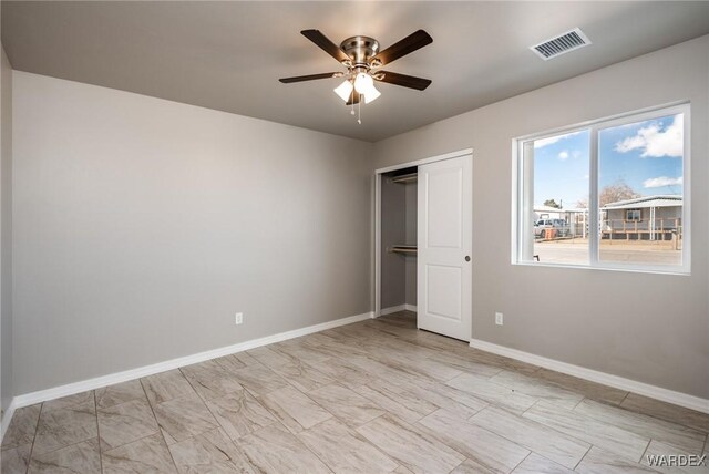 empty room with a ceiling fan and baseboards