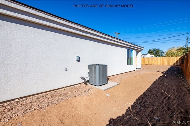 view of home's exterior with cooling unit, a fenced backyard, and stucco siding