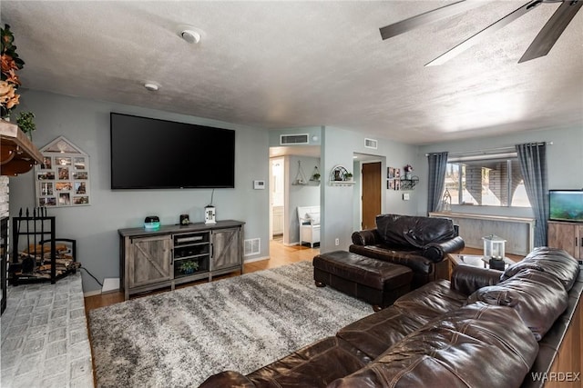 living area with a textured ceiling and visible vents