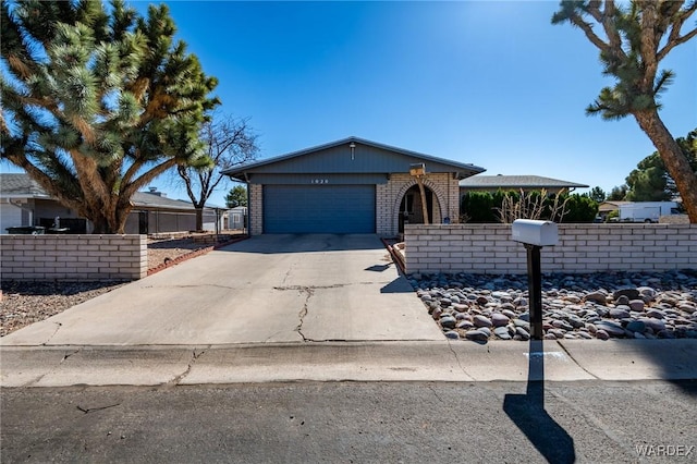 ranch-style home featuring a garage, driveway, brick siding, and fence