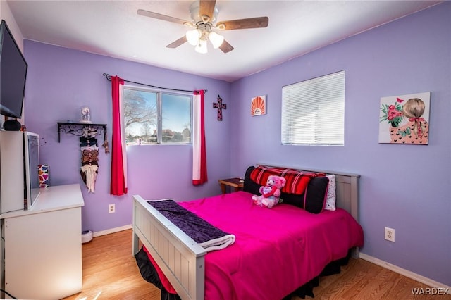 bedroom with ceiling fan, baseboards, and wood finished floors