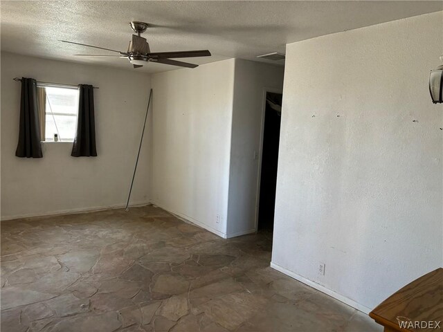 unfurnished room featuring ceiling fan, a textured ceiling, and visible vents