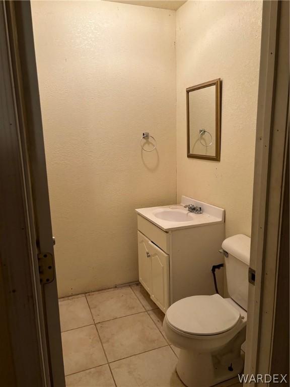 bathroom with tile patterned flooring, vanity, and toilet