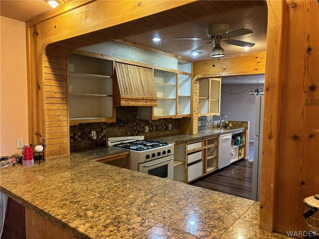 kitchen featuring white appliances, decorative backsplash, a ceiling fan, custom range hood, and a sink