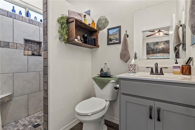 2602 Bear Mountain Loop, Bullhead City, AZ 86442 - bathroom featuring toilet, vanity, a tile shower, a ceiling fan, and baseboards