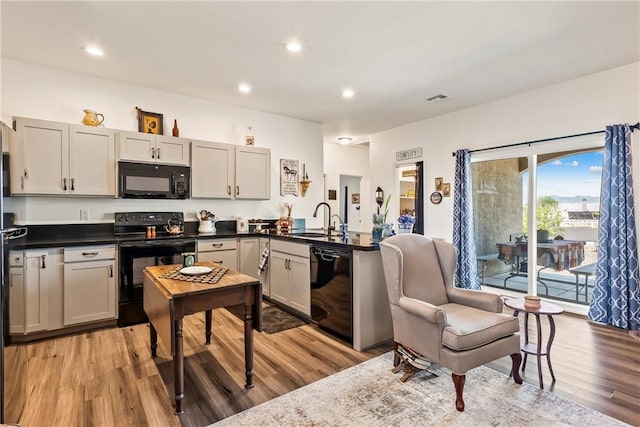 2602 Bear Mountain Loop, Bullhead City, AZ 86442 - kitchen with black appliances, a sink, light wood finished floors, dark countertops, and recessed lighting