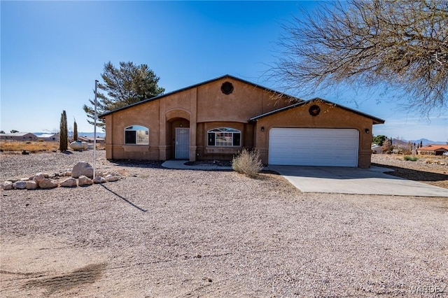 view of front of property with a garage, driveway, and stucco siding