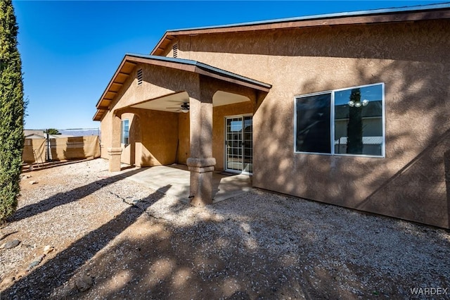 rear view of house featuring a patio, a ceiling fan, and stucco siding