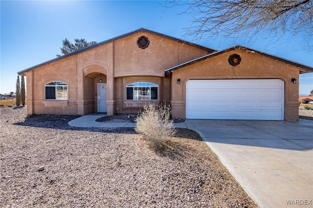 view of front of house with stucco siding, an attached garage, and driveway