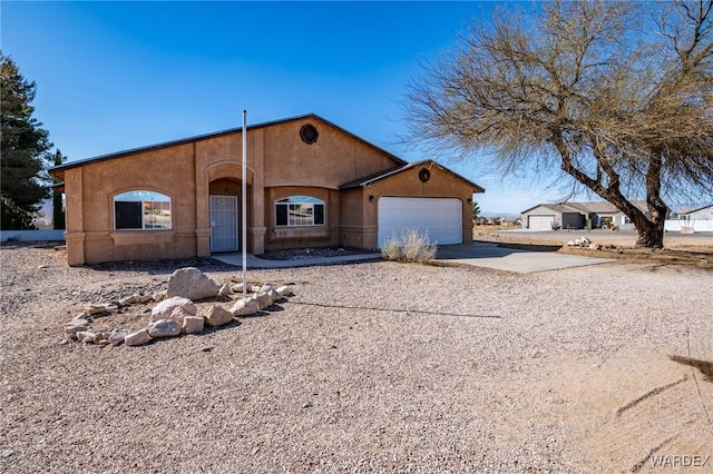 view of front of house featuring stucco siding, driveway, and a garage