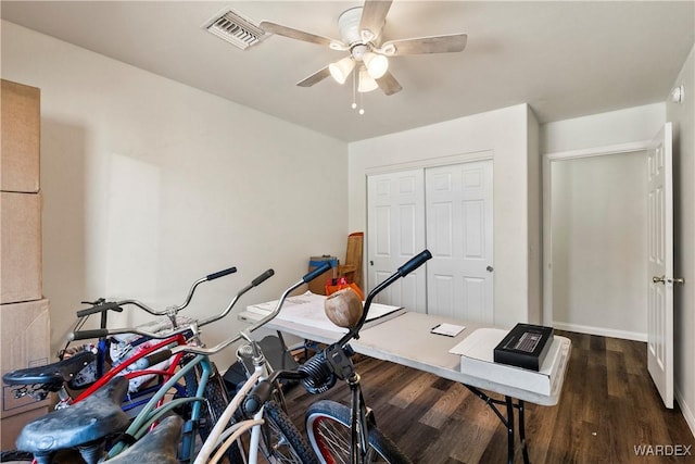 exercise room with dark wood-type flooring, visible vents, and a ceiling fan