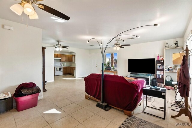 living area with light tile patterned floors, baseboards, and a ceiling fan