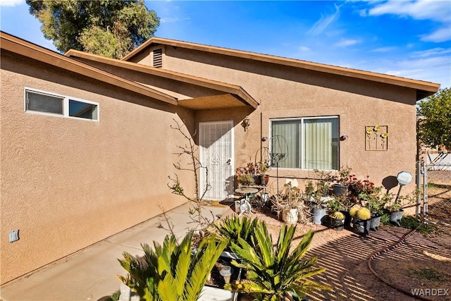 doorway to property with a patio and stucco siding