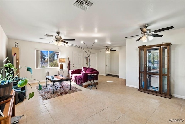 living area with a ceiling fan, visible vents, baseboards, and light tile patterned floors