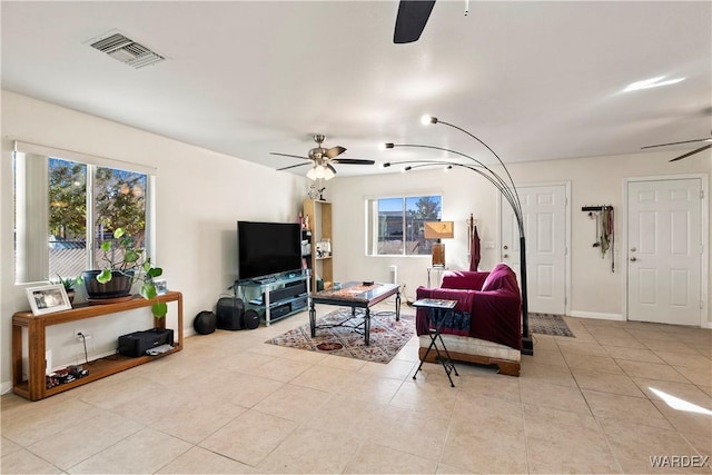 living room with baseboards, visible vents, a ceiling fan, and light tile patterned flooring