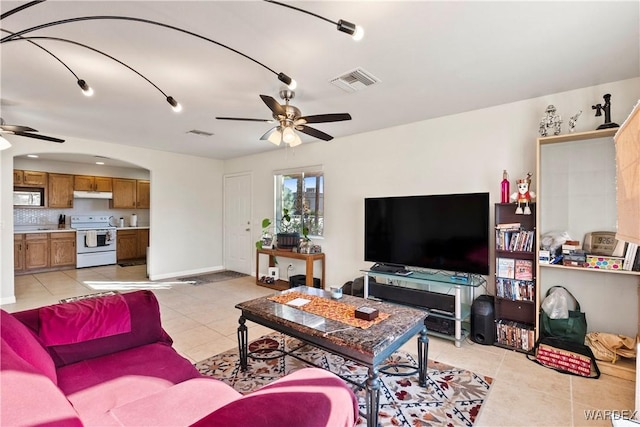 living area with light tile patterned floors, baseboards, visible vents, and a ceiling fan