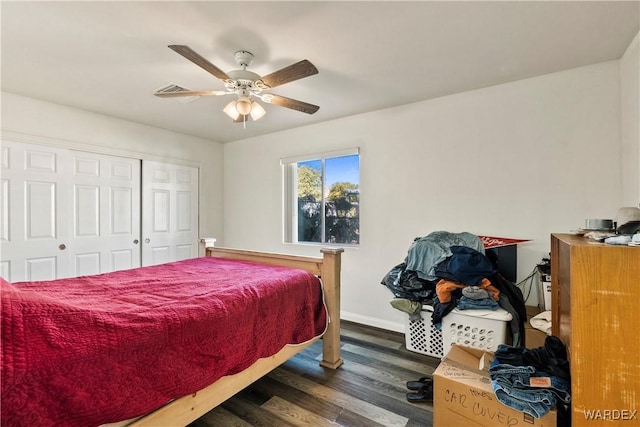 bedroom with dark wood-type flooring, a closet, ceiling fan, and baseboards