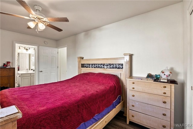 bedroom with a ceiling fan, dark wood finished floors, a sink, and ensuite bathroom