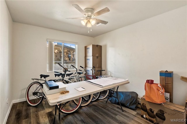 office space with a ceiling fan, baseboards, and dark wood-type flooring