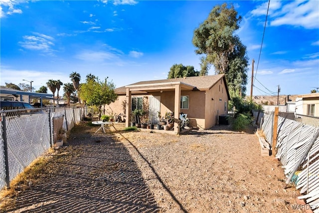 back of property featuring central air condition unit, a fenced backyard, and stucco siding