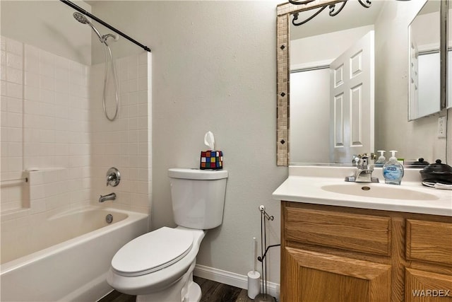 bathroom featuring toilet, wood finished floors, vanity, bathing tub / shower combination, and baseboards