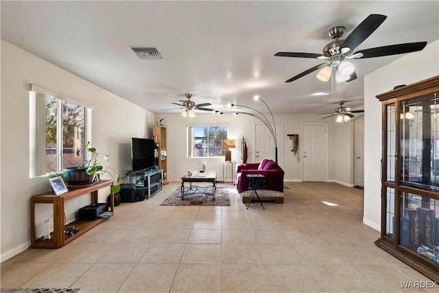 living room with light tile patterned floors, baseboards, and visible vents