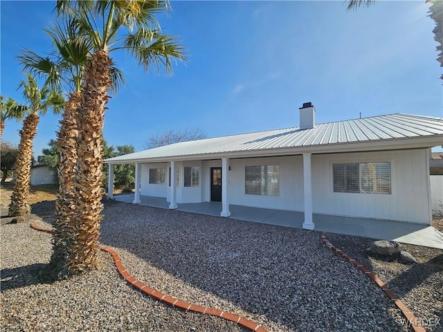 view of front of home featuring metal roof and a chimney