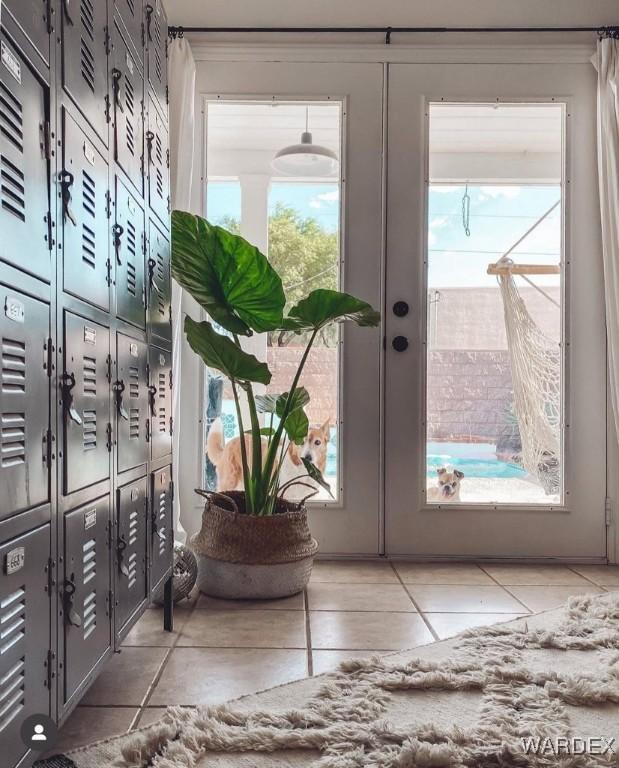 doorway to outside featuring french doors, plenty of natural light, and tile patterned flooring