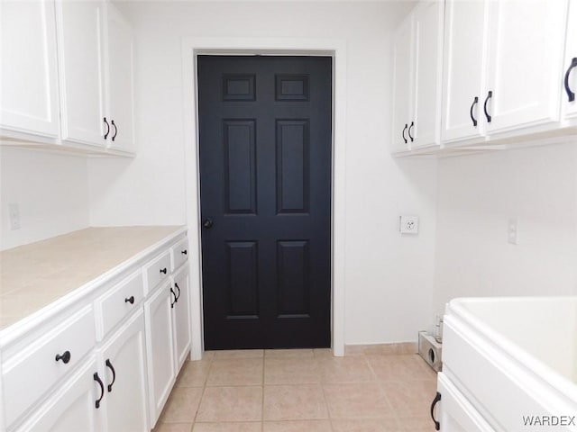 kitchen with light tile patterned floors, tile countertops, and white cabinets