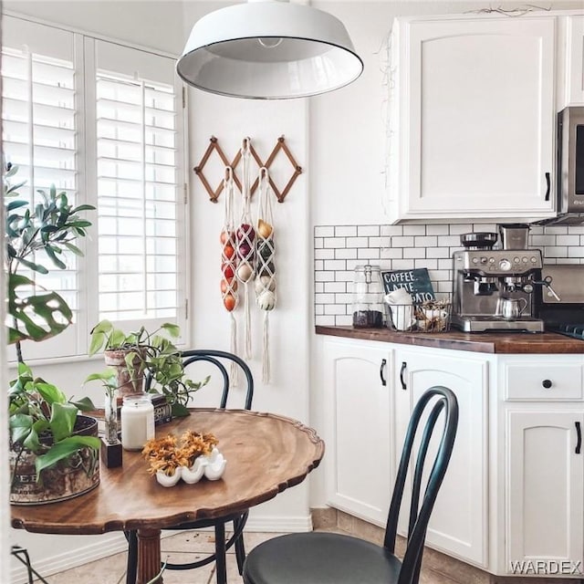 kitchen featuring white cabinets, wood counters, and decorative backsplash