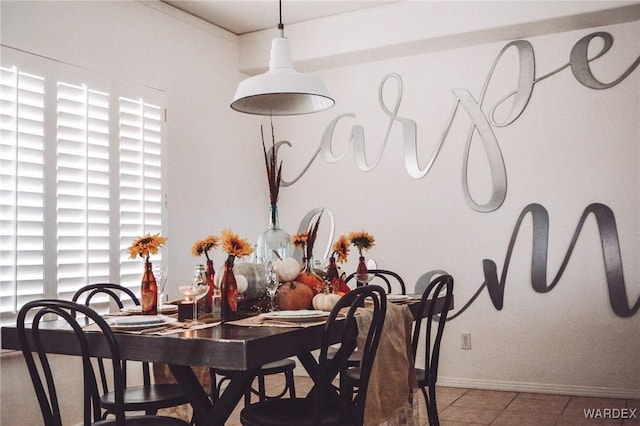 tiled dining area featuring baseboards