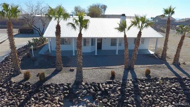 back of house featuring metal roof