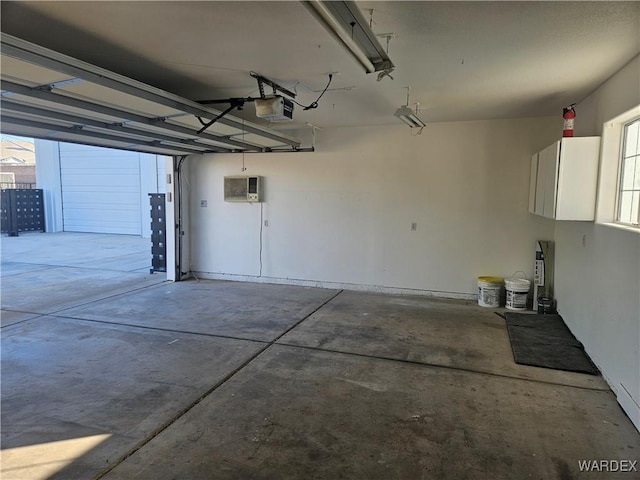 garage featuring an AC wall unit and a garage door opener