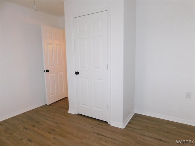 empty room featuring baseboards and wood finished floors