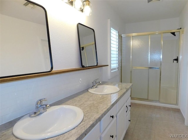 full bathroom with a stall shower, a sink, and decorative backsplash