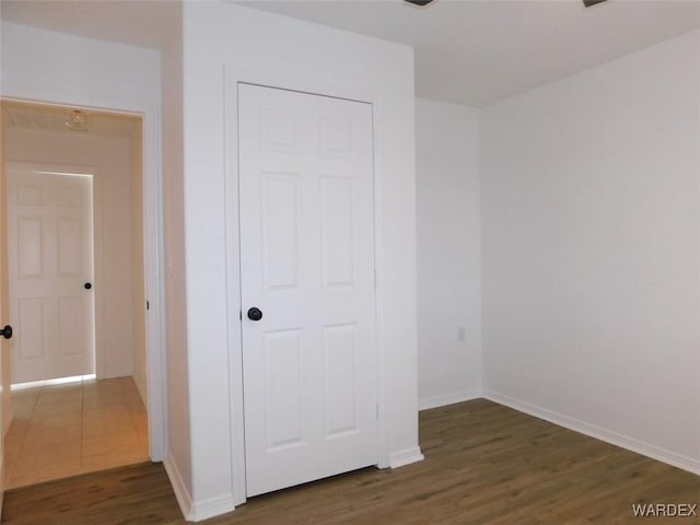 unfurnished bedroom with baseboards and wood finished floors