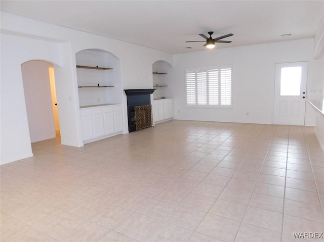 unfurnished living room with built in shelves, visible vents, ceiling fan, and light tile patterned floors