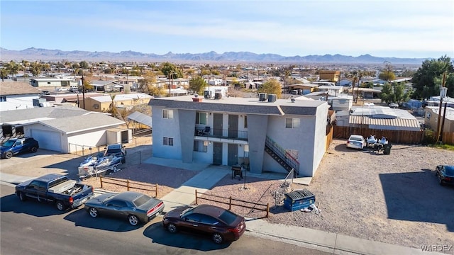 view of front of house featuring a residential view, a mountain view, and fence