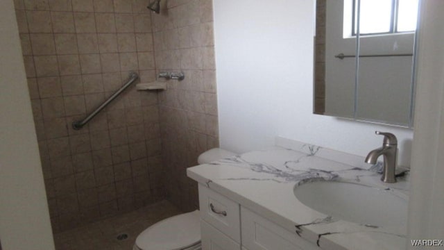 bathroom with toilet, vanity, and a stall shower