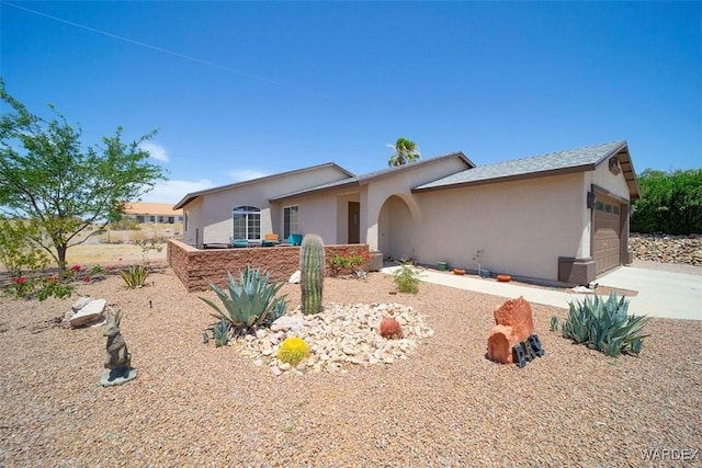 single story home with a garage, driveway, and stucco siding